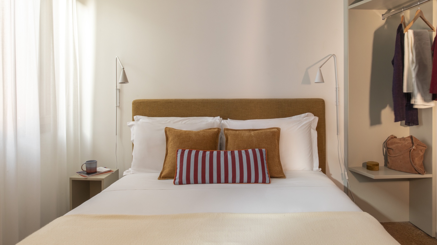 Detail of modern double bed in Standard room with textured ochre pillows and modern wall lamps - Ca' La Stampa, BZAR hotels in Venice