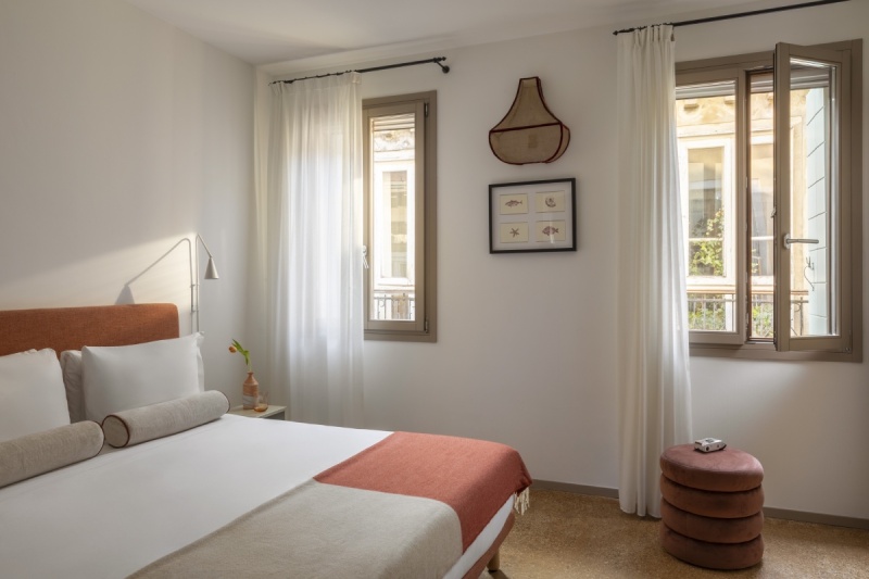 Camera Superior luminosa a Venezia con letto matrimoniale, testiera arancione, pouf di design e vista esterna - Ca' La Stampa, BZAR hotels a Venezia