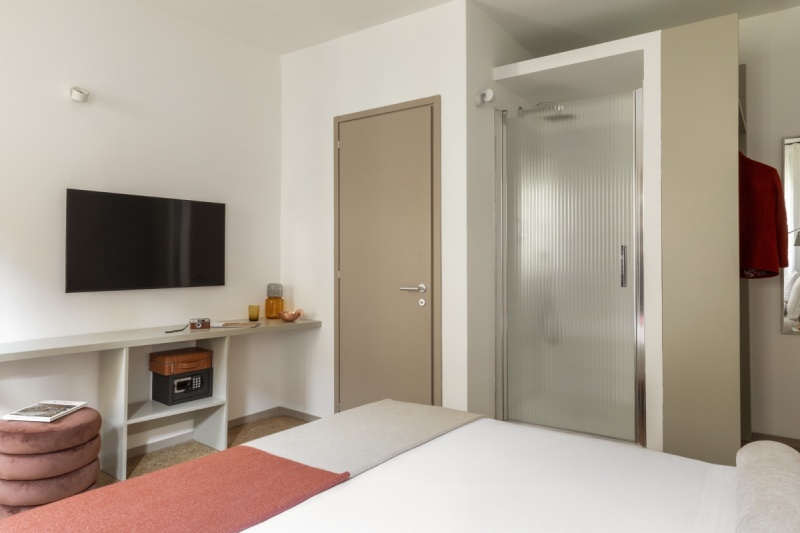 Zona notte camera Superior con TV a schermo piatto, scrivania minimalista e moderna doccia con vetro satinato - Ca' La Stampa, BZAR hotels a Venezia